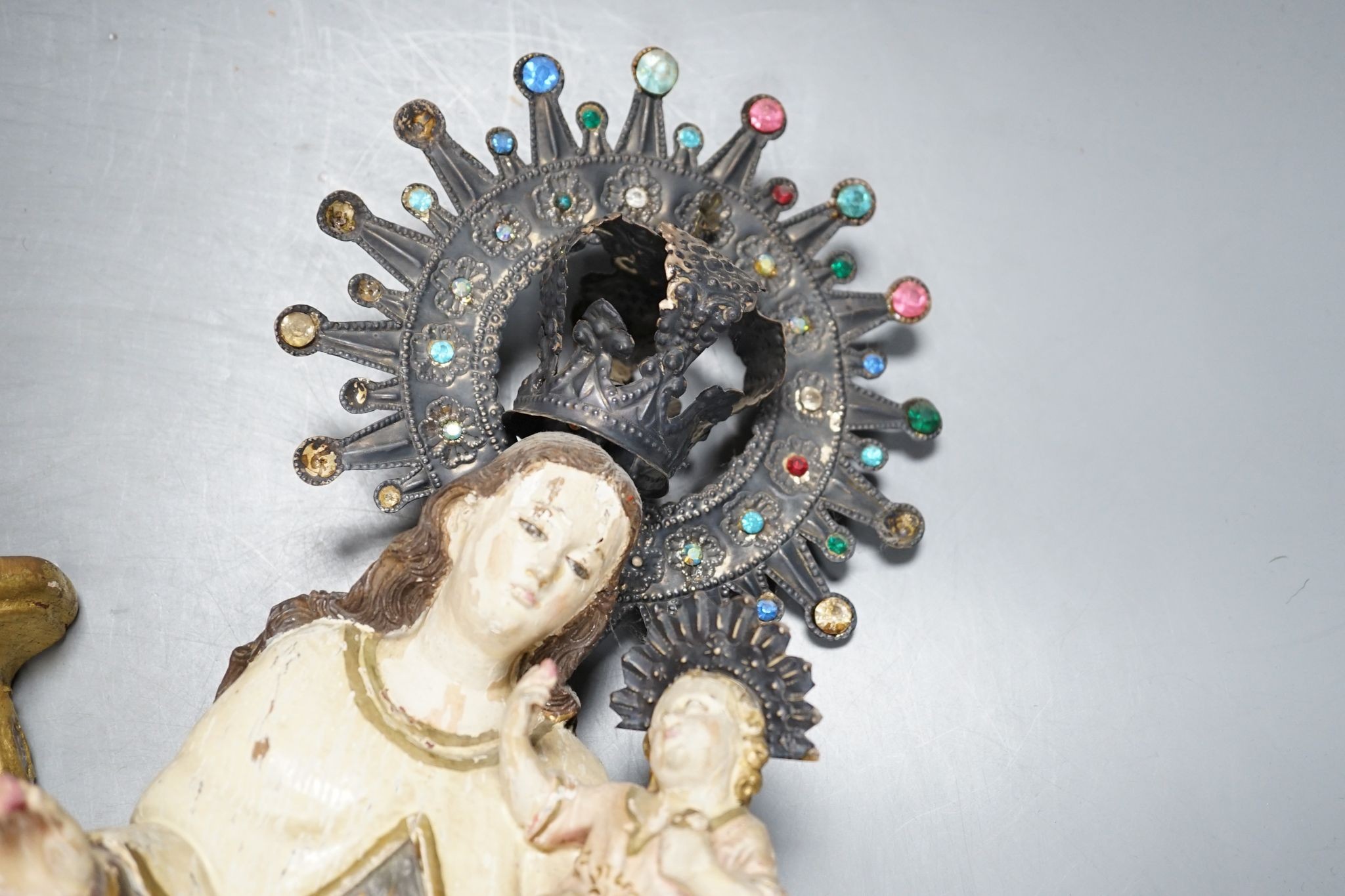 An ornate South American Madonna and child with a metal crown and halo, standing on a carved bracket, 39cm